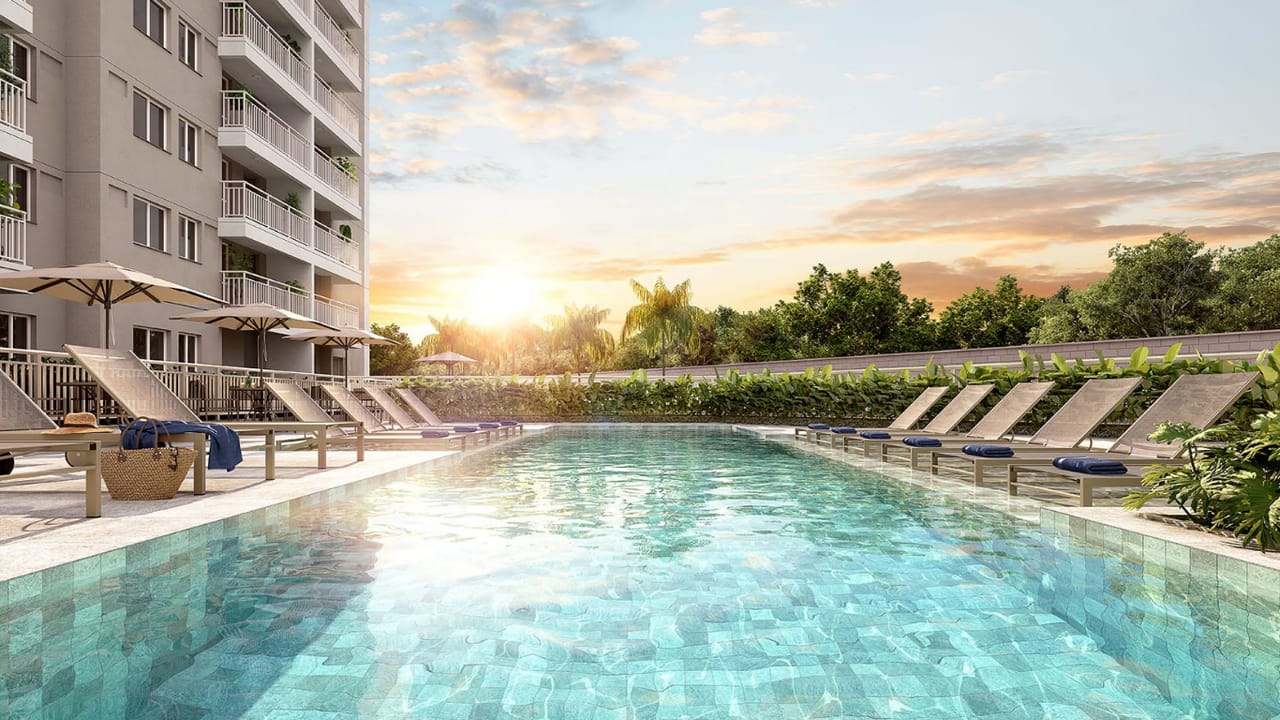 Perspectiva da piscina do Residencial Ivone Lara com espreguiçadeiras ao pôr do sol