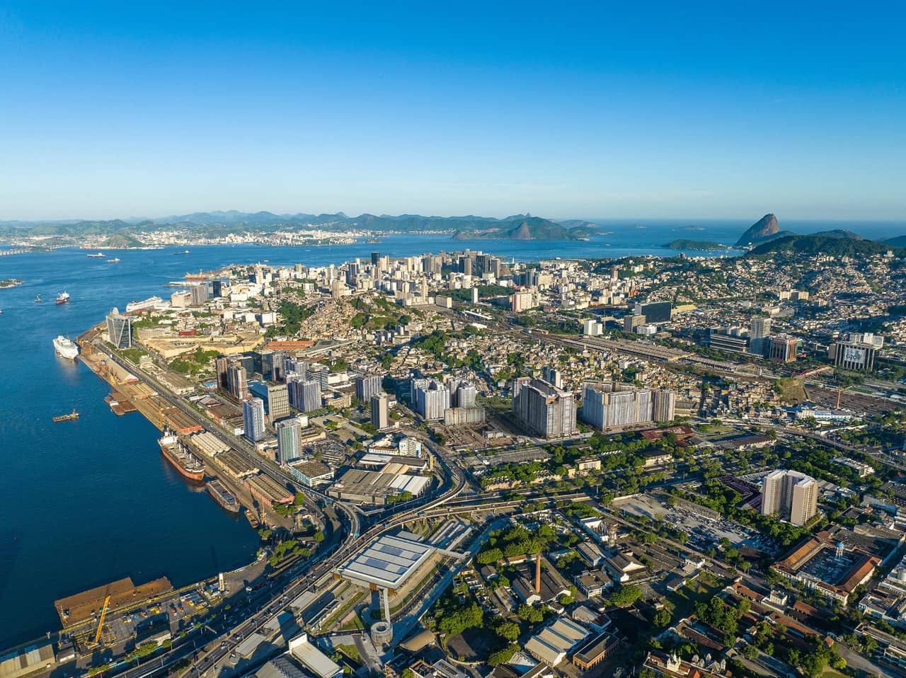 Vista aérea diurna do Santo Cristo e da orla portuária, com a Baía de Guanabara e Niterói ao fundo